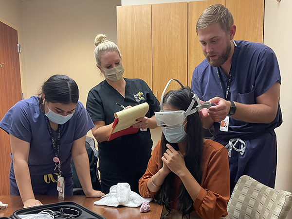 A research team led by Summer Ott, PsyD, practices the placement of the Nurocheck device for future patients with concussions. From left to right: Keyla D. Guevara, Ott, Tanya Cheema, Jordan J. Harmon. (Photo courtesy of Dr. Summer Ott)